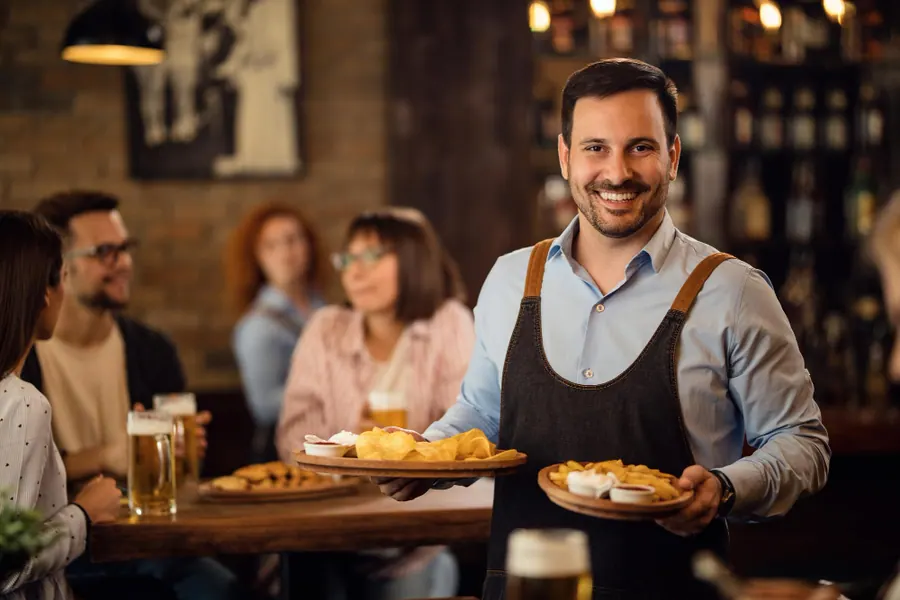Equipe de restaurante servindo clientes com segurança e qualidade