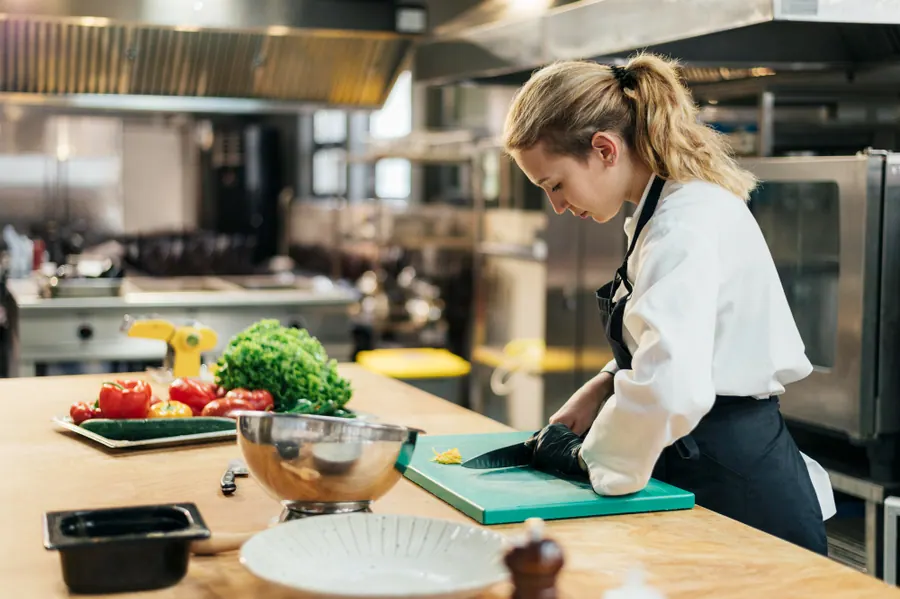 Chef registrando a ficha técnica de uma preparação na cozinha